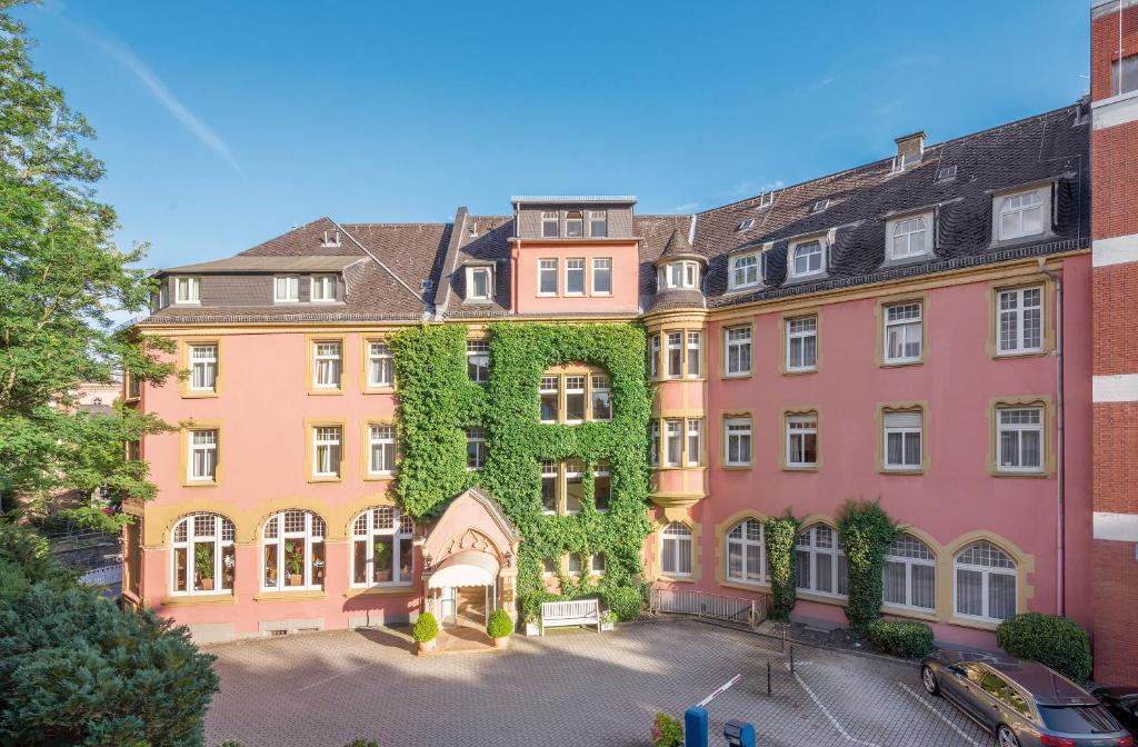 un gran edificio con hiedra a un lado en Hotel Oranien Wiesbaden en Wiesbaden