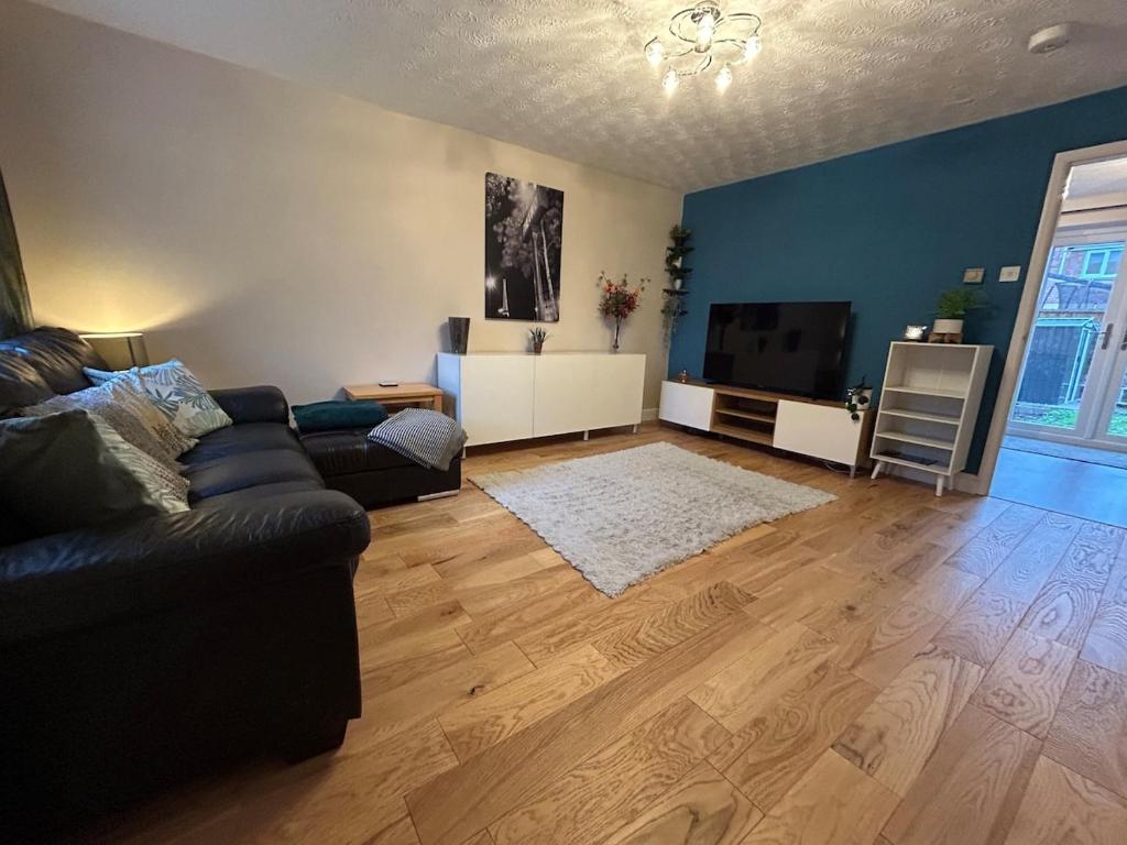 a living room with a couch and a flat screen tv at 3 Bedroom, Parking, 2 Toilets, Wi-Fi, Modern in Crewe