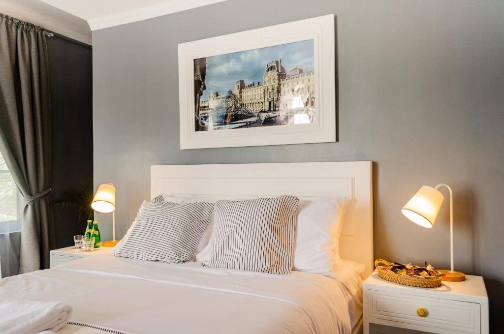 a bedroom with a white bed and two lamps at Hotel Bijoux in Plaridel