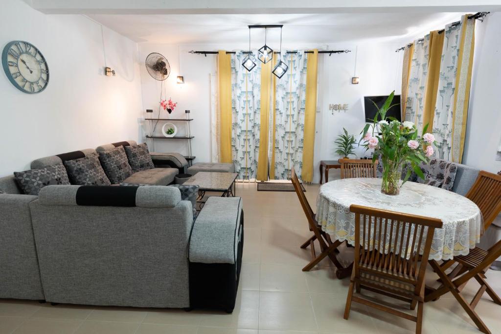 a living room with a couch and a table at Spacious Coastal Home Steps from the Beach in Flic-en-Flac