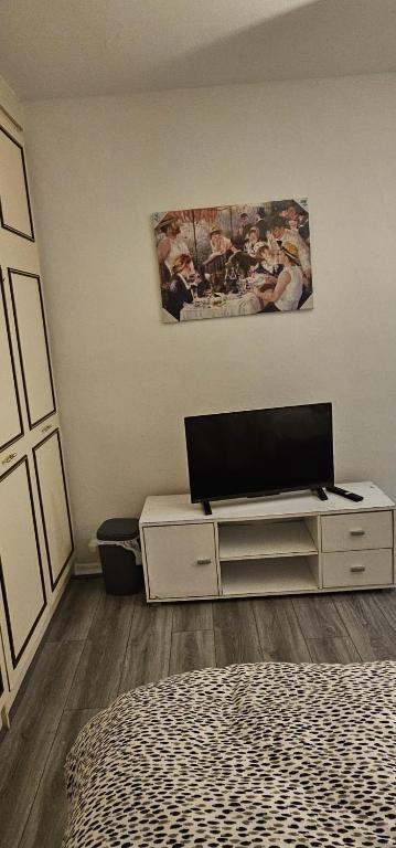 a bedroom with a bed and a dresser with a laptop on it at Heywhyjas in Manchester