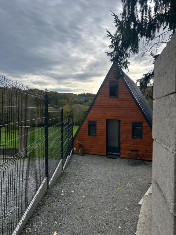 a barn with a fence in front of it at L Atypique in Saint-Éloi