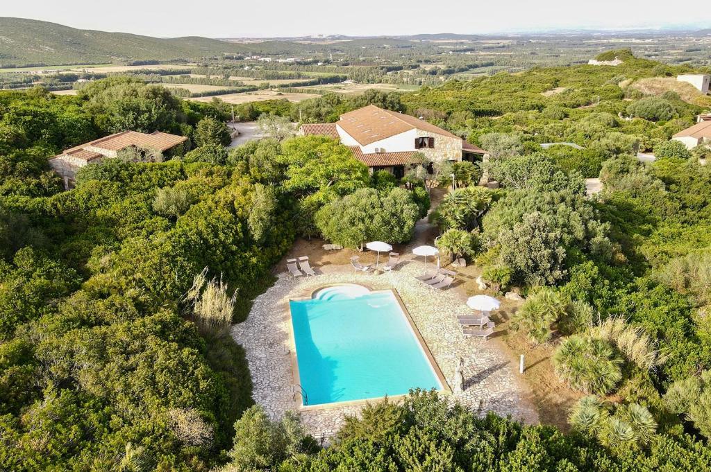 eine Luftaufnahme einer Villa mit Swimmingpool in der Unterkunft Village surrounded by greenery with swimming pool just a few minutes from Alghero in Alghero