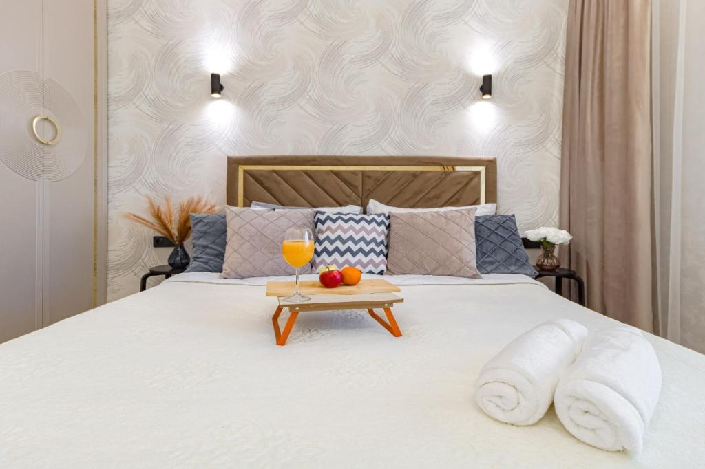 un lit avec un plateau avec une boisson et des fruits dessus dans l'établissement ЖК Поколение, Байтерек, Абу Даби 434, à Astana