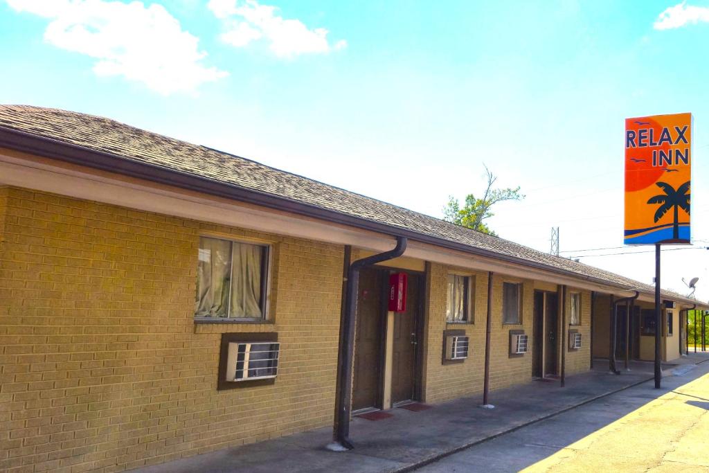 a building with a sign that reads relax inn at Relax Inn by OYO Sulphur Hwy 90 in Sulphur