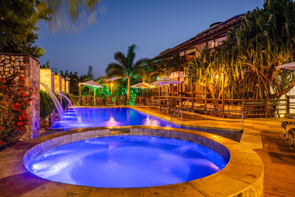 a large swimming pool with a water fountain at Pousada Carcará in Jericoacoara