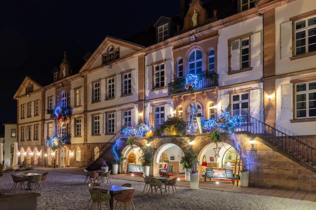 圣伊波利特Hôtel Val-Vignes Colmar Haut-Koenigsbourg, The Originals Relais的一群夜晚有蓝色灯光的建筑