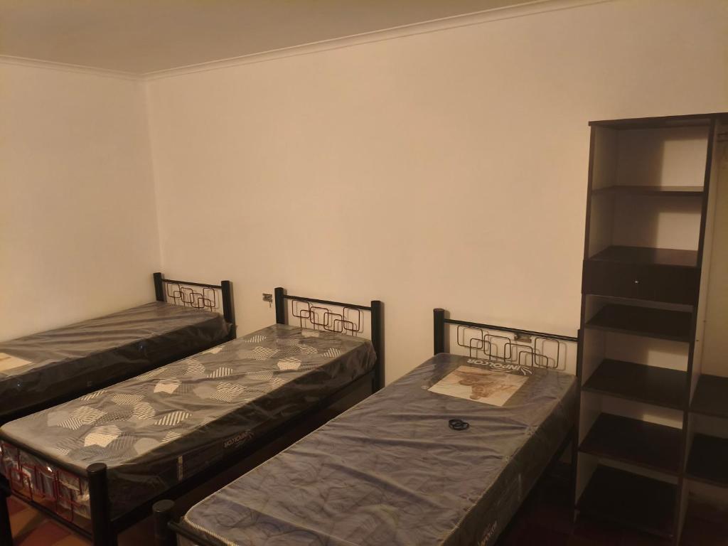 Zimmer mit 2 Betten und einem Regal in der Unterkunft La Casa de Elisa in Santa Rosa de Calamuchita