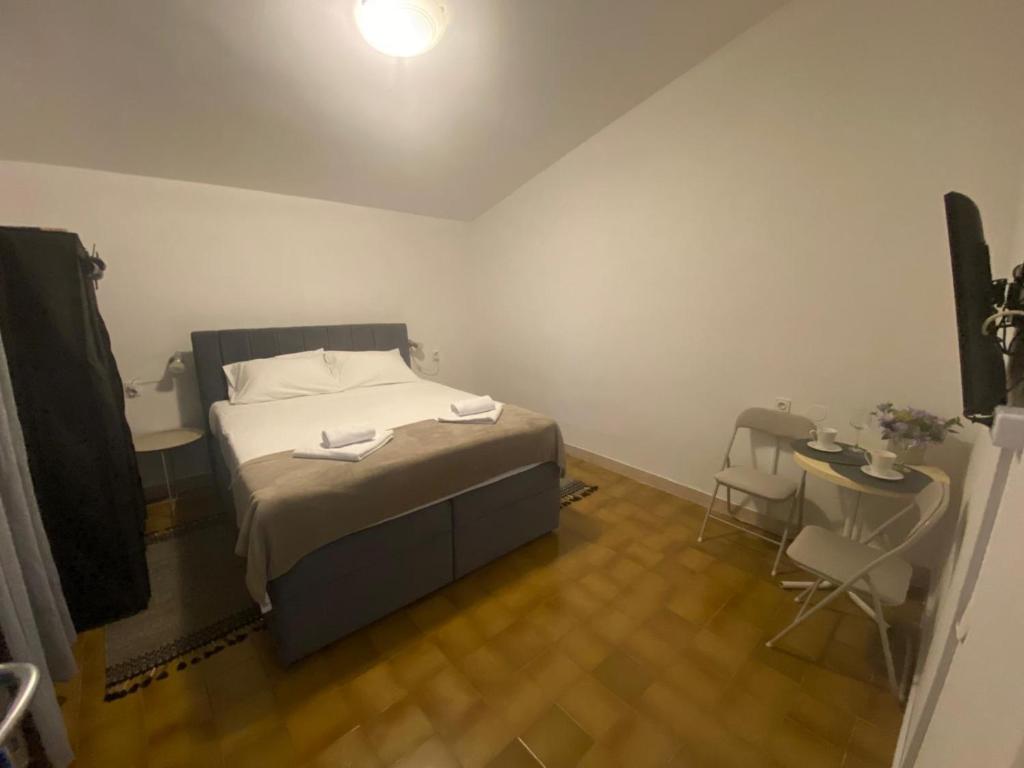 a bedroom with a bed and a table and chairs at Ganzha Appart in Medulin