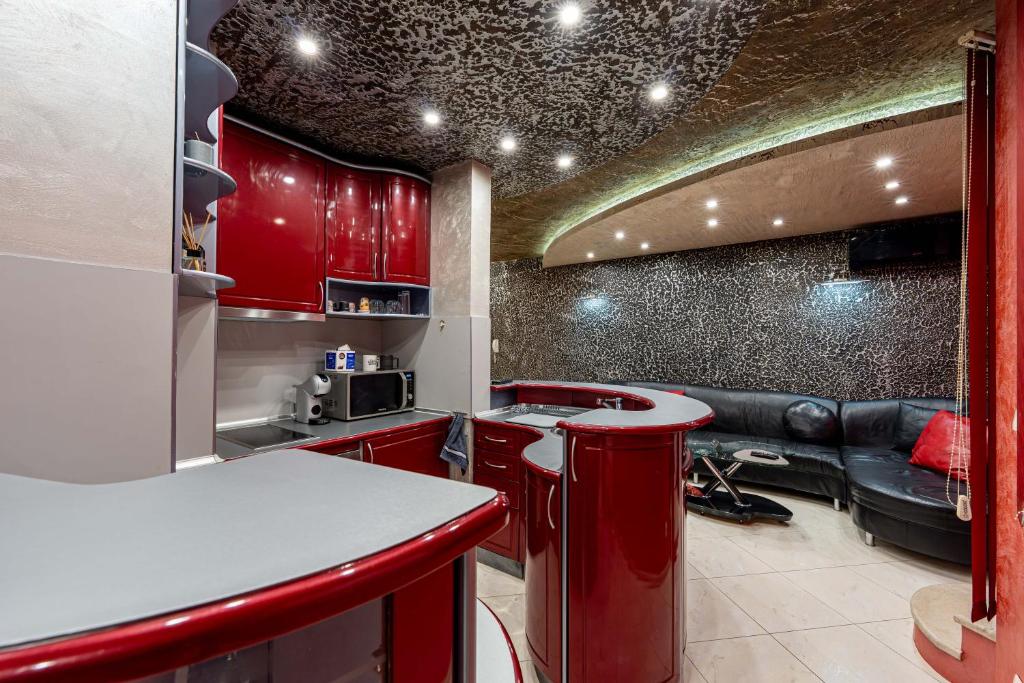 eine Küche mit roten Schränken und einem Sofa in der Unterkunft Beni Deluxe 1 in Plowdiw