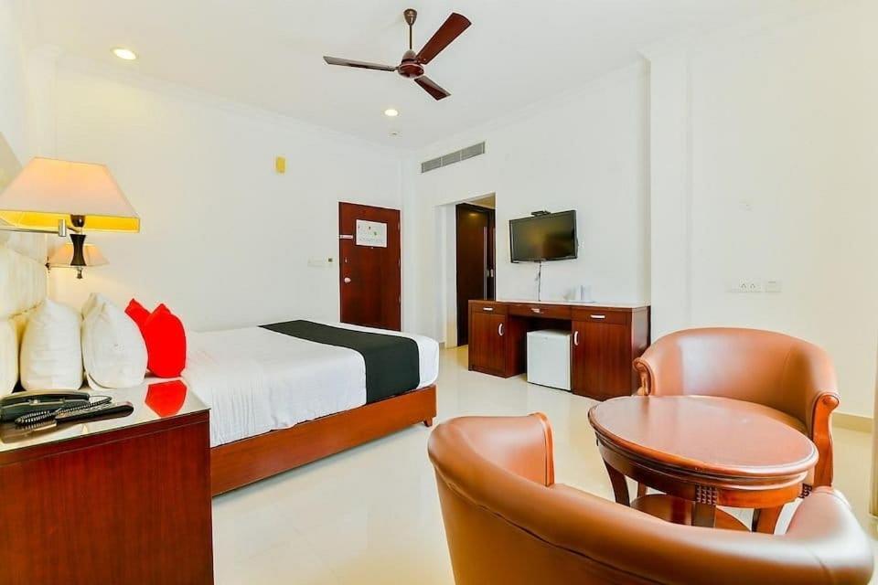 a bedroom with a bed and a desk with a chair at Ajantha Regency in Cochin