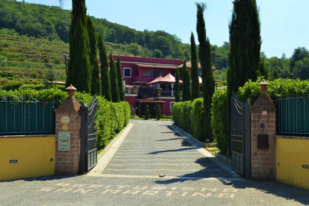 波佐利的住宿－Agriturismo San Martino，通往有门和树木的房子的车道