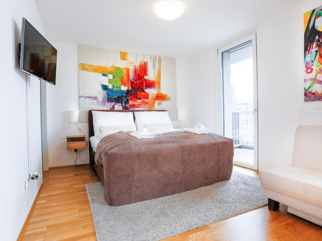 a bedroom with a bed and a television in it at Penthouse Studio with Terrace and City View - 5 mins walk to Hauptbahnhof Train Station in Vienna
