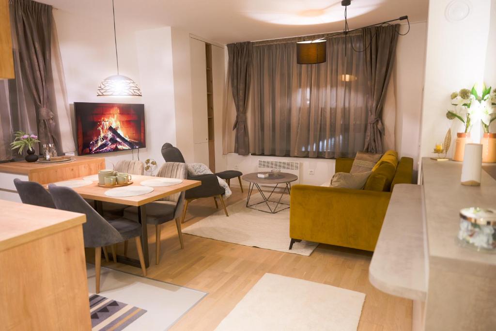 a living room with a table and chairs and a couch at Bjelasnica Bliss Apartment in Bjelašnica