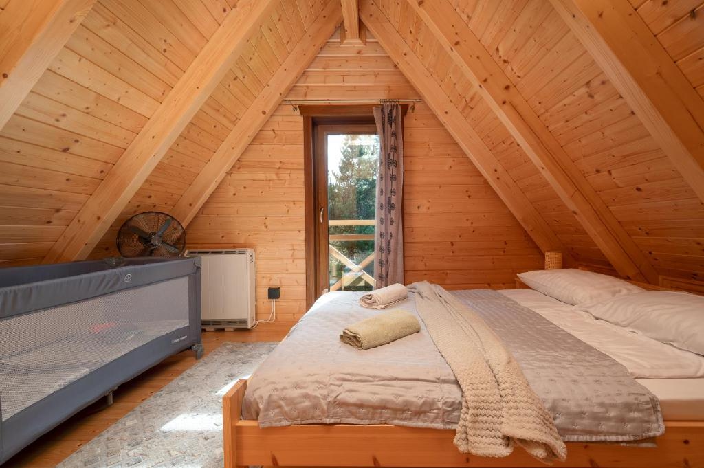 a bedroom with a bed in a wooden cabin at Domek w ciszy i zieleni w górach w Łopusznej, przyjmujemy psy bezpłatnie, ogrodzona działka in Łopuszna