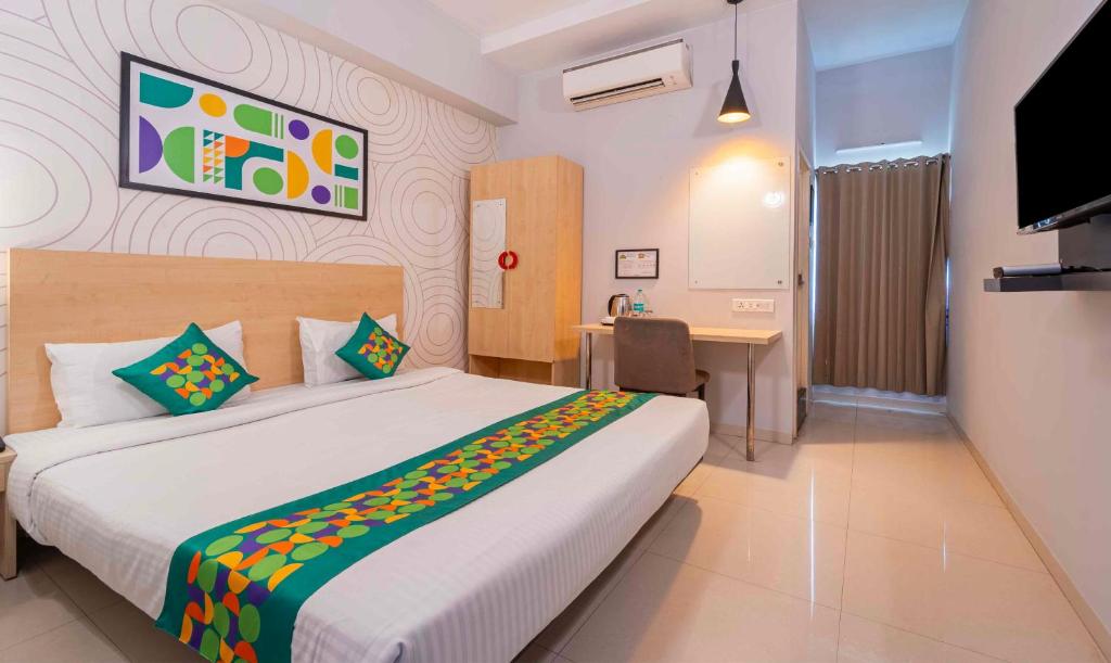 a bedroom with a bed and a desk and a television at Treebo Skyry Residency in Coimbatore