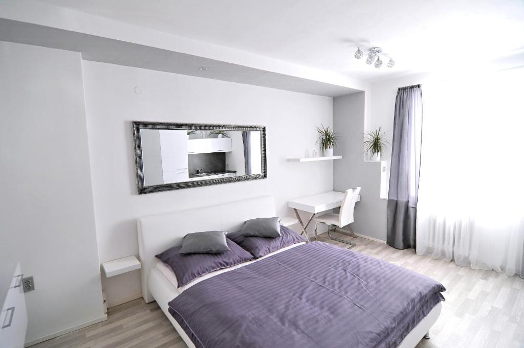 a bedroom with a bed with a mirror and a desk at AVAX apartment Liberec in Liberec