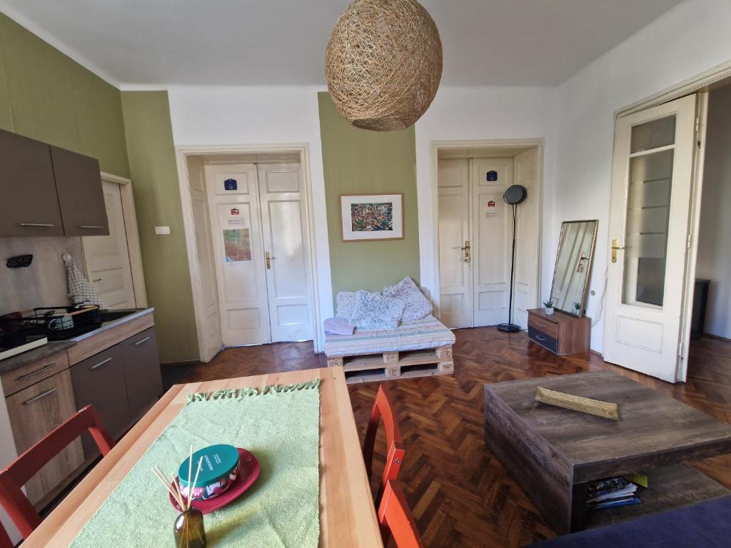 un soggiorno con tavolo e cucina di Central Station Private Rooms a Belgrado