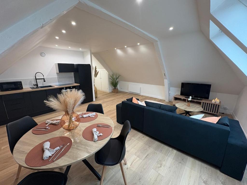 Una sala de estar con un sofá azul y una mesa. en Le Cocon Arras Centre & Netflix 4 pers, en Arras