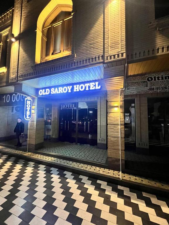 a man walking in front of an old savory hotel at Old Saroy Hotel in Samarkand