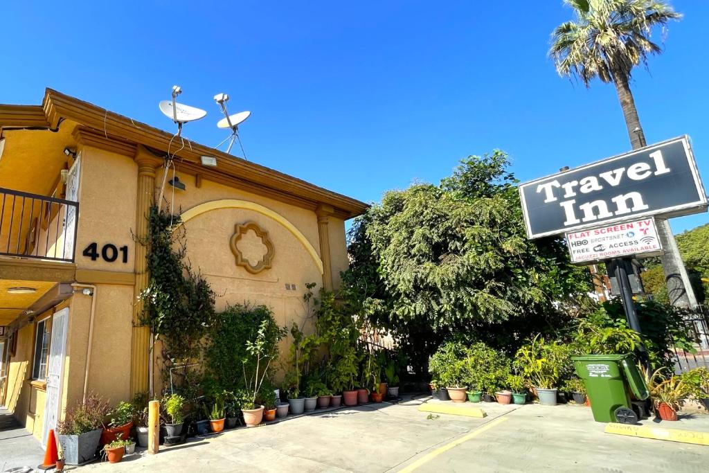 a sign for a travel inn next to a building at Travel Inn Downtown LA in Los Angeles