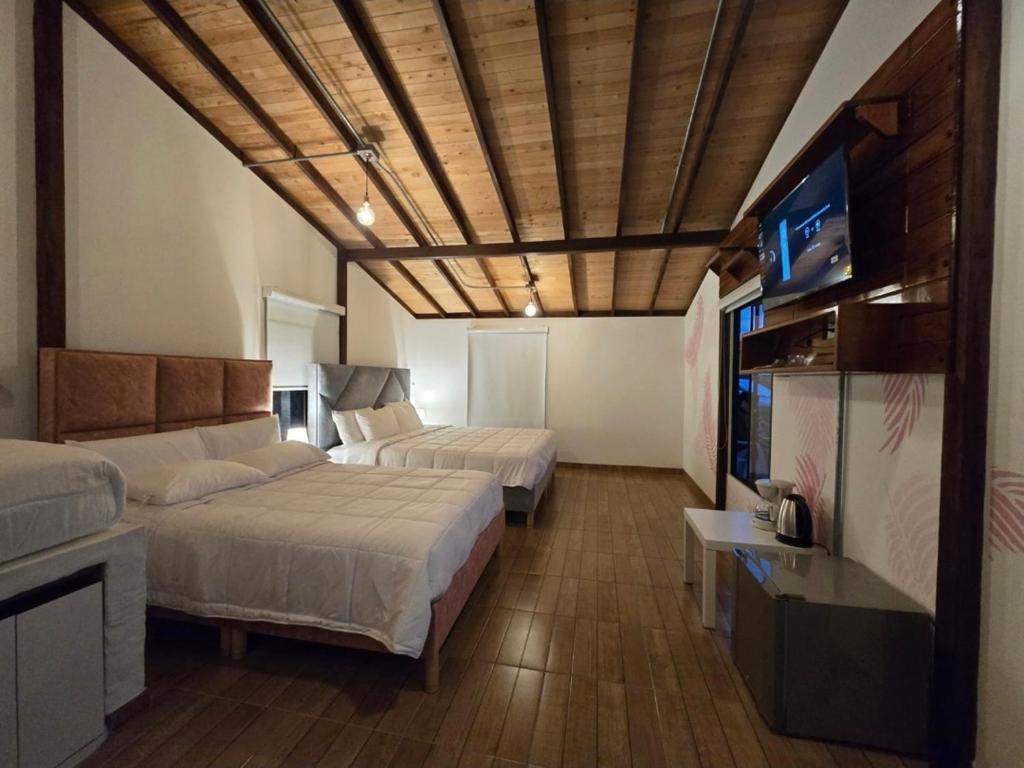 a bedroom with two beds and a couch and a tv at Manawa Kaona in Somondoco