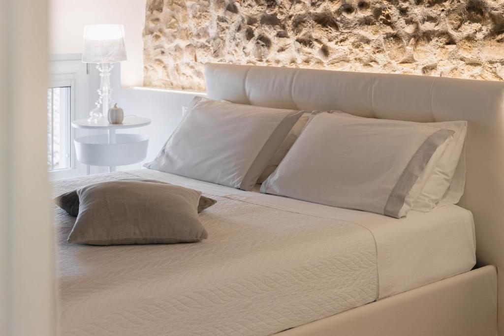 a bed with white sheets and pillows in a bedroom at Affittacamere CASA DOLCE CASA SAN DANIELE in San Daniele del Friuli