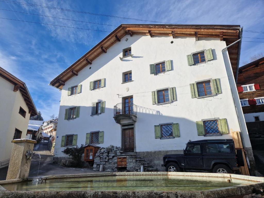 un edificio blanco con un camión estacionado frente a él en Patrizer Haus in Bergbauerndorf, en Cazis