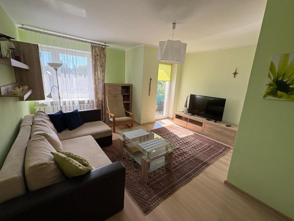 a living room with a couch and a coffee table at Lokum u Joanny in Nowy Łupków