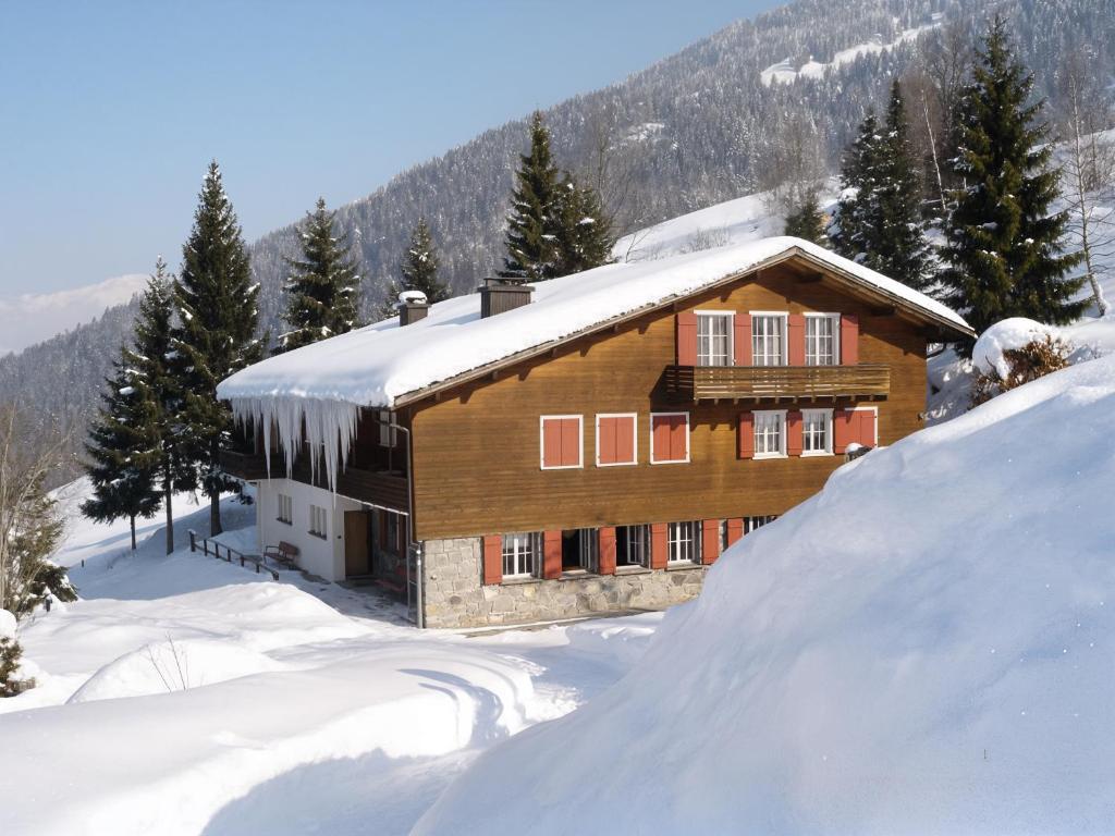 a house covered in snow with a pile of snow at Swiss Horizon-Gruppenhaus Mullern, vielseitiges Haus für Familien, Gruppen, Seminare und Gemeinschaft in Mollis
