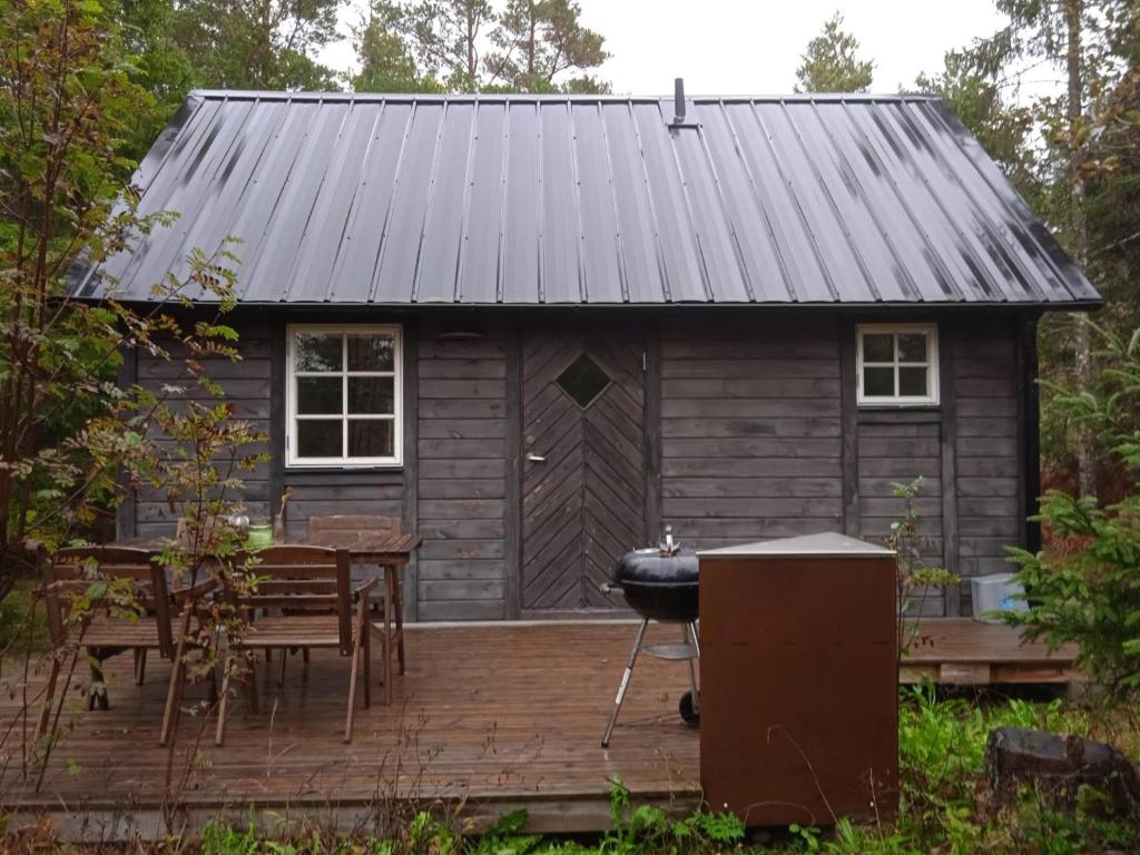 a log cabin with a grill and a table and chairs at Stunning Home In Lärbro With One Bedroom in Kappelshamn