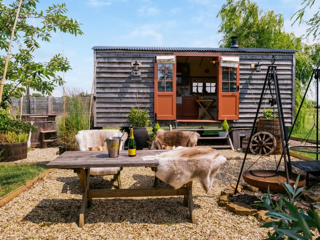 a tiny house with two dogs sitting around a table at Bonnie's Shepherd Hut - Uk50228 in Nottingham