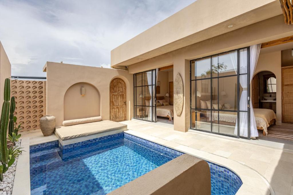 Pasir 5 - A stylish 2 bed villa in Bingin w pool في Bingin Beach: فيلا مع حمام سباحة وغرفة نوم