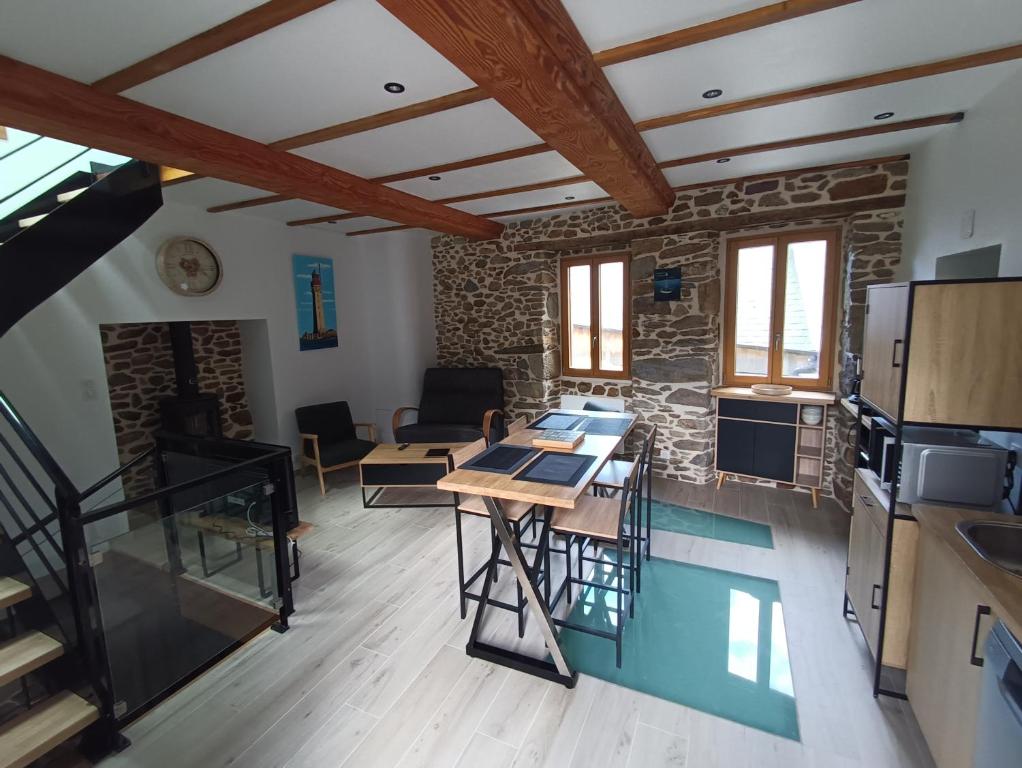 a kitchen and living room with a stone wall at Rêve et Rance in La Richardais