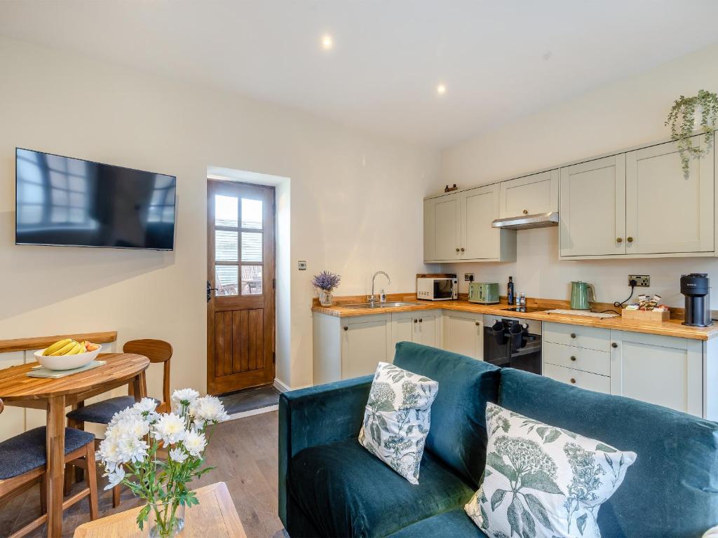a living room with a couch and a kitchen at Peartree Cottage - Uk45496 in Great Budworth