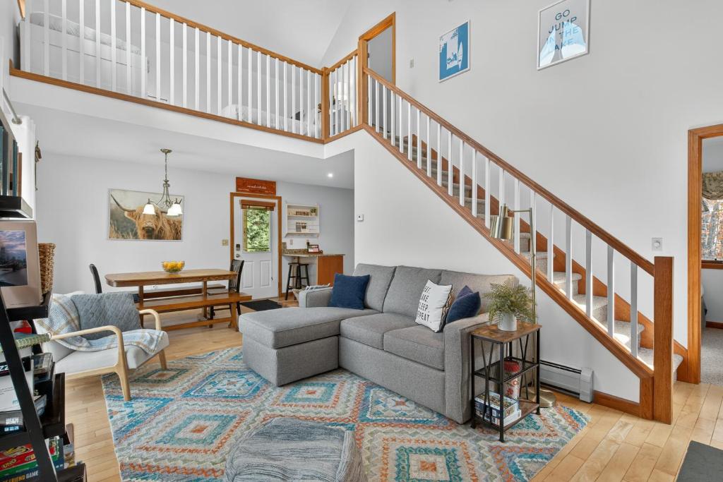 a living room with a couch and a staircase at VT Lake house minutes from Okemo in Ludlow