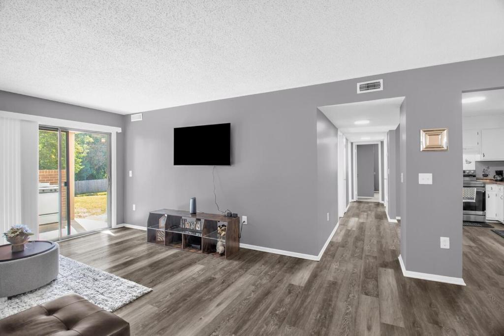 an empty living room with a flat screen tv at Modern 3BR 2 bathroom Near High Point University & Market Sleeps 6 in High Point