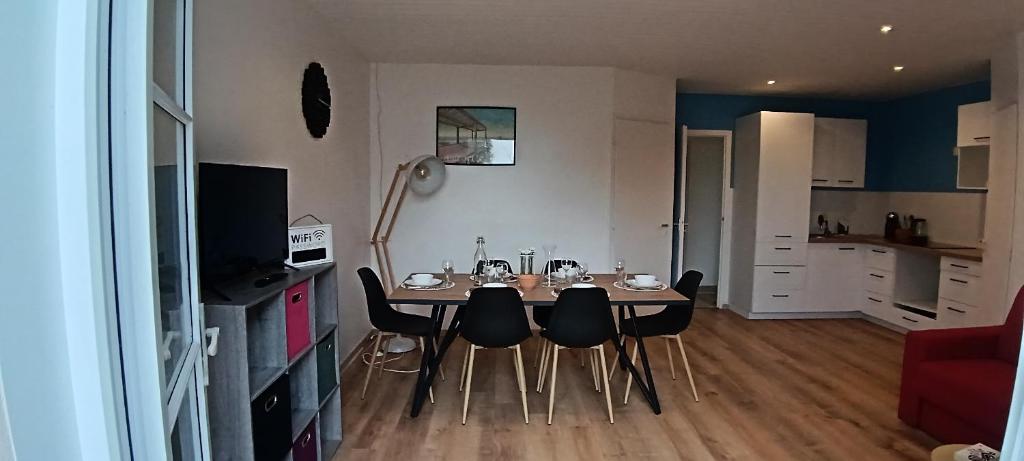 a dining room table and chairs in a living room at Notre Dame de Monts Entre mer et marais in Notre-Dame-de-Monts