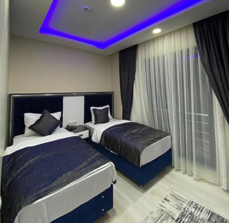 a bedroom with two beds and a purple ceiling at Ögel Apart Otel in Sarıkamıs
