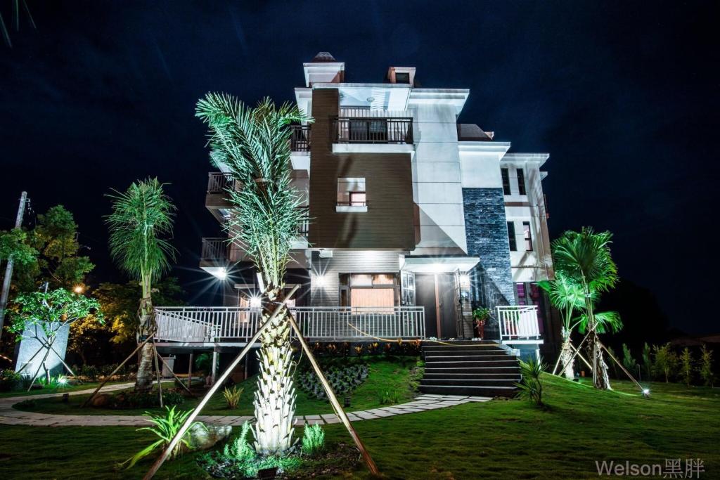 a large house with palm trees in front of it at Sophia B&amp;B in Dongshan