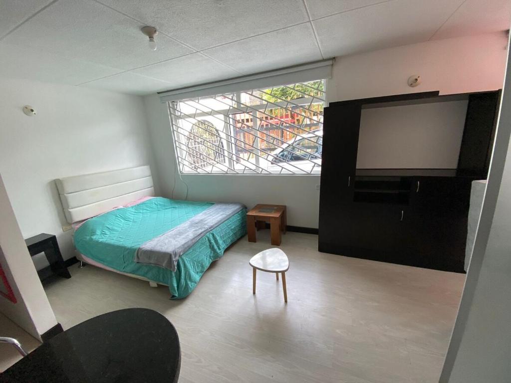 a bedroom with a bed and a flat screen tv at casas bosque apartaestudio in Bogotá