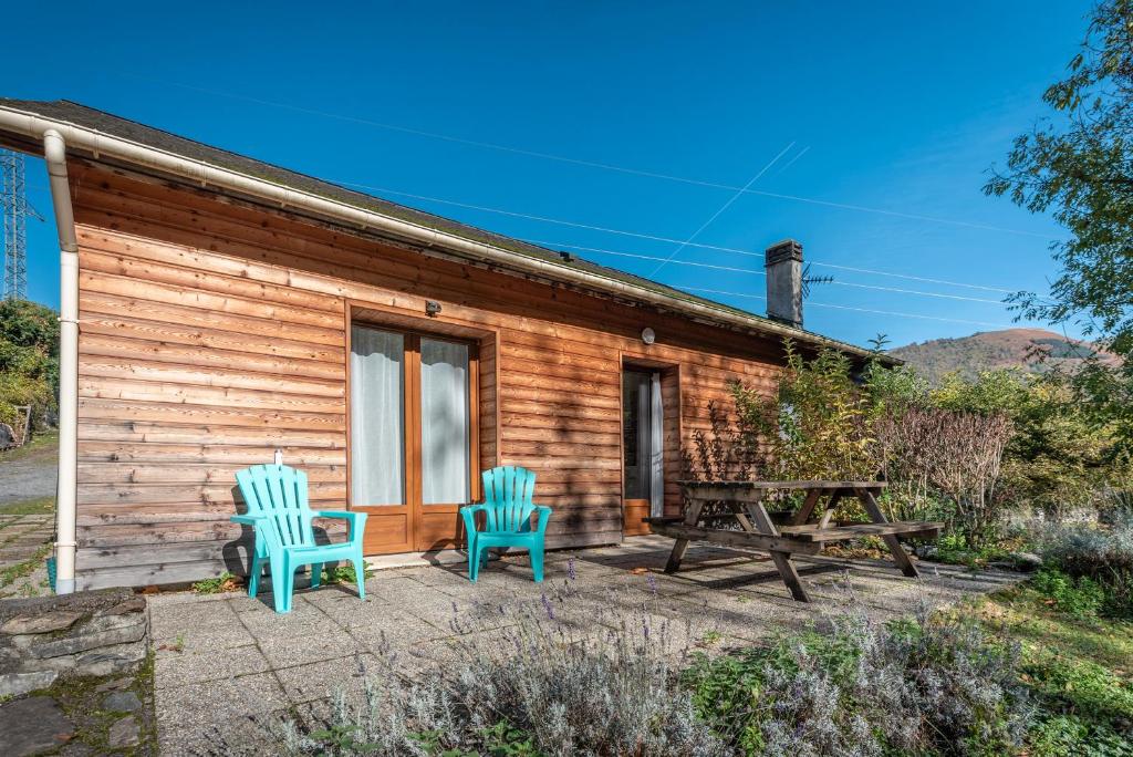 une cabane en bois avec deux chaises et une table de pique-nique dans l'établissement Chalets De L’arriutort - Laruns, à Laruns