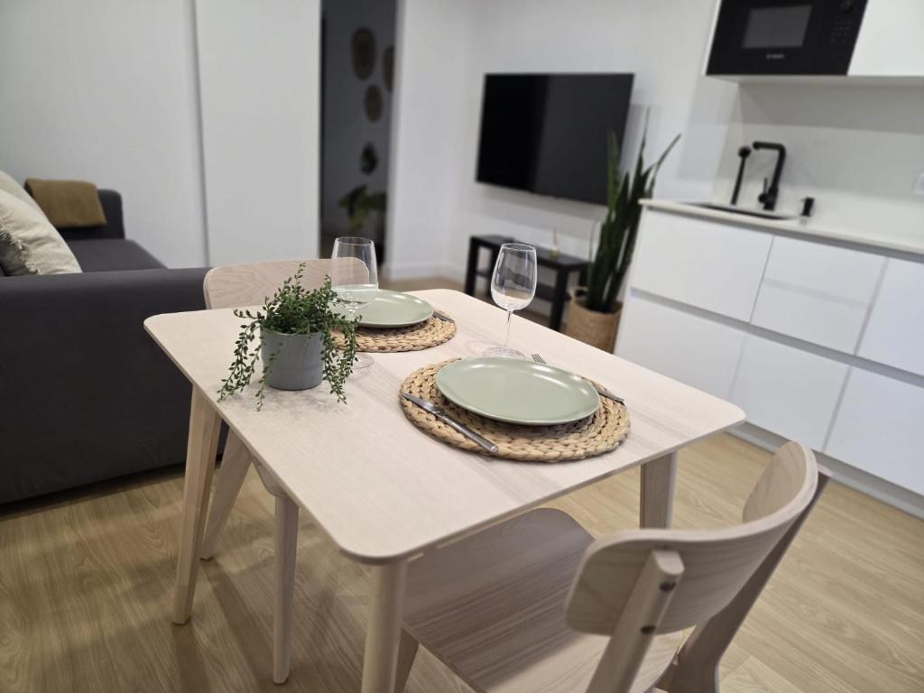 a white table with two plates and wine glasses at Gardel Esencia in Icod de los Vinos