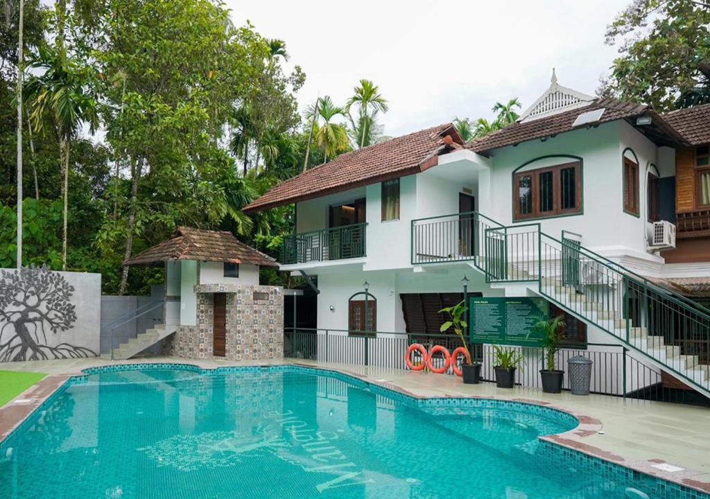 une villa avec piscine devant une maison dans l'établissement Mangrove Heritage Home, Chendamangalam, à Cochin