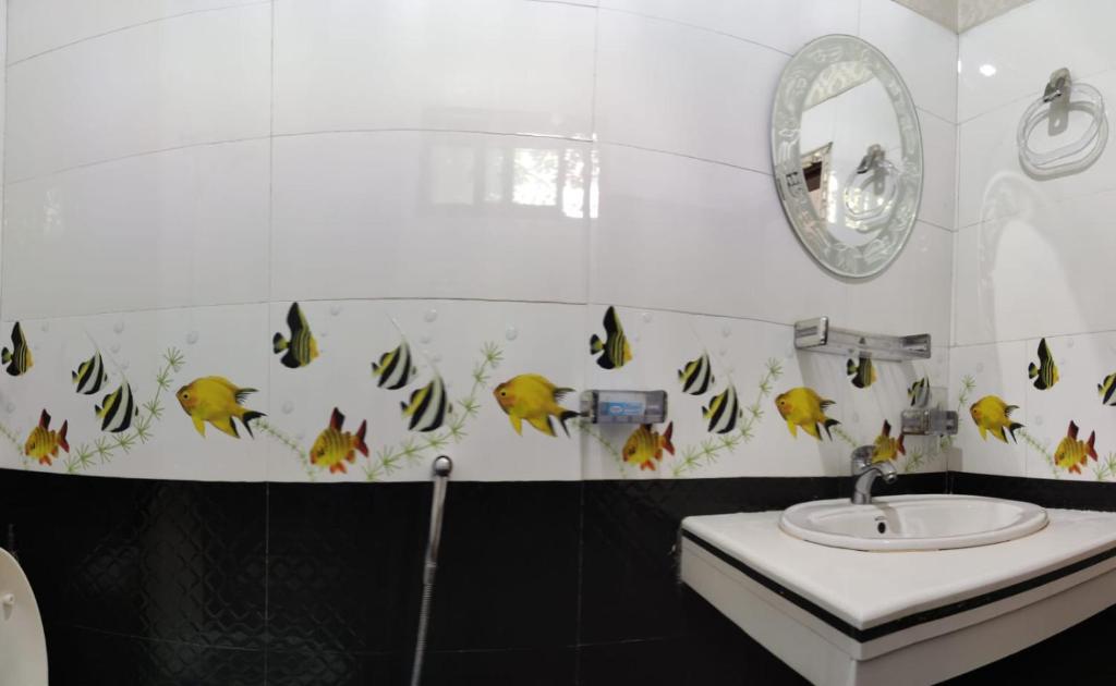 a bathroom with a sink and a mirror at Grand Family Hotel in Lahore