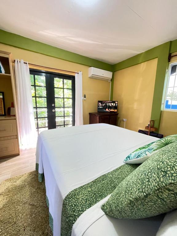 une chambre avec un grand lit blanc et une fenêtre dans l'établissement Cinnamon Cottage - Peaceful retreat in nature, à Soufrière