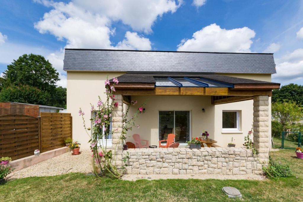 een klein huisje met een stenen muur en een solarium bij Les hortensias in Grâces