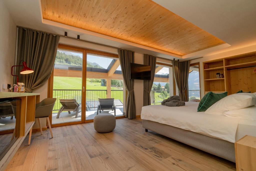 a bedroom with a bed and a table and chairs at Funivia Bormio Active Hotel - Adults Only in Bormio