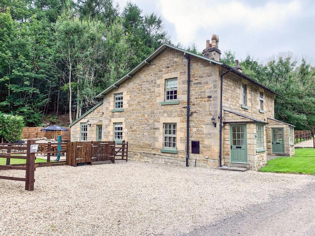 an old stone building with a fence in front of it at Hudson Cottage - Uk38152 in Newton