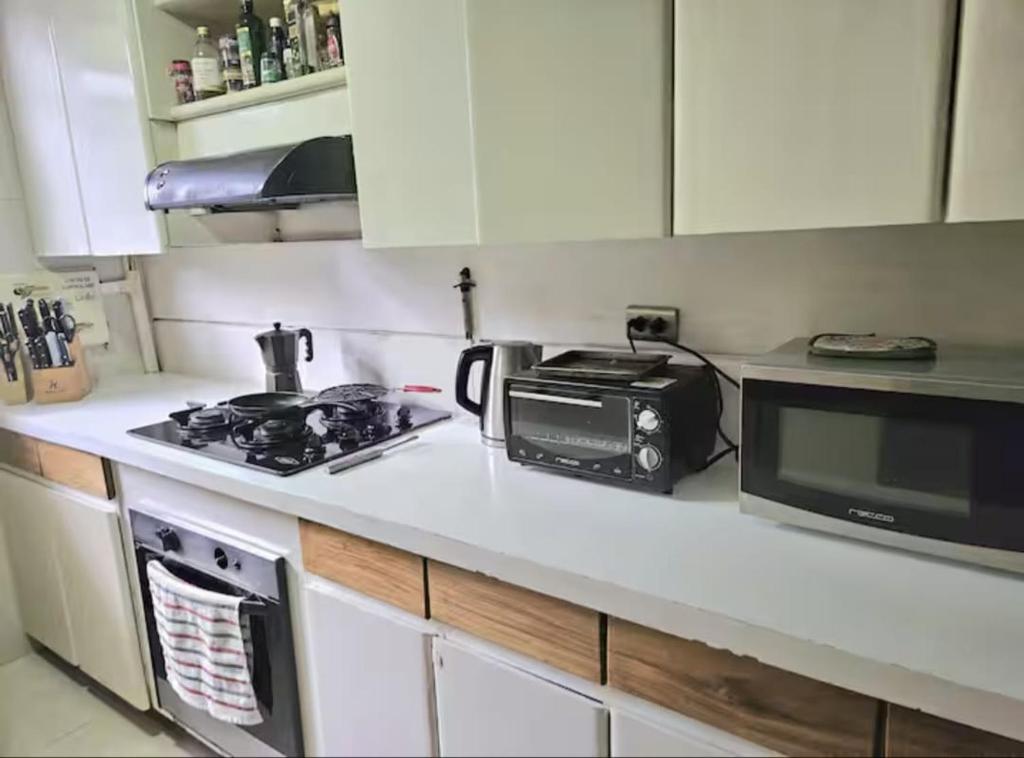 a kitchen counter with a microwave and a stove at master bedroom in Medellín